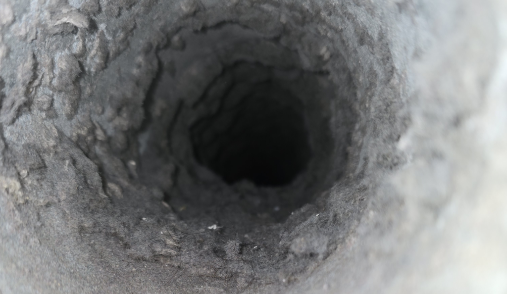 Lint buildup inside a dryer vent before professional cleaning